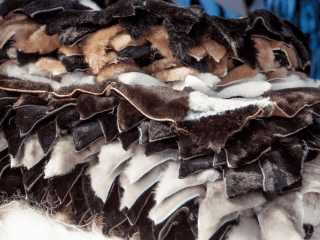 The Fur Cache A stack of layered, irregularly cut pieces of fur and leather in shades of brown, black, and white. The texture and color variations suggest they are animal pelts or scraps prepared for crafting. The best place to buy and sell furs, leather, pelts, leather products and more.