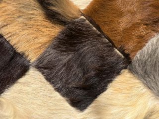 The Fur Cache A close-up of a patchwork surface made of fur squares in various shades of brown, tan, cream, gray, and black, showing soft textures and natural color variations. The best place to buy and sell furs, leather, pelts, leather products and more.